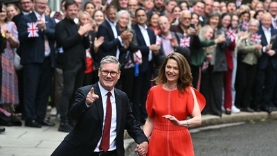Britain's Prime Minister Keir Starmer and leader of the Labour Party, and his wife Victoria thank supporters after he addressed the nation following his general election victory, in Downing Street in London on Friday. (AFP)
