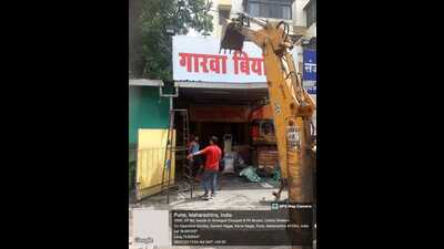 The PMC anti-encroachment department cleared the footpaths and roads in the area of illegal establishments. (HT PHOTO)