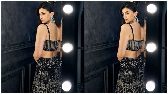 Her bralette-style blouse boasts spaghetti straps and a sweetheart neckline. She paired it with a matching flared skirt and a black sheer cape adorned with sequin borders, adding a touch of drama to her look.(Instagram/@aliaabhatt)