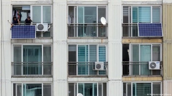 Residents in South Korea installing solar panels beside their air conditioner.(YNA/dpa/picture alliance)