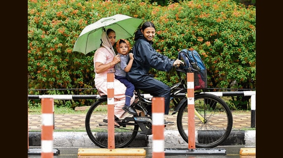 A family on its way amid the rain in Chandigarh on Friday (Ravi Kumar/HT)