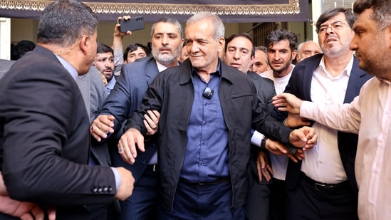 Iranian reformist presidential candidate Masoud Pezeshkian (C) leaves a polling station after voting in Tehran on July 5, 2024. (AFP)