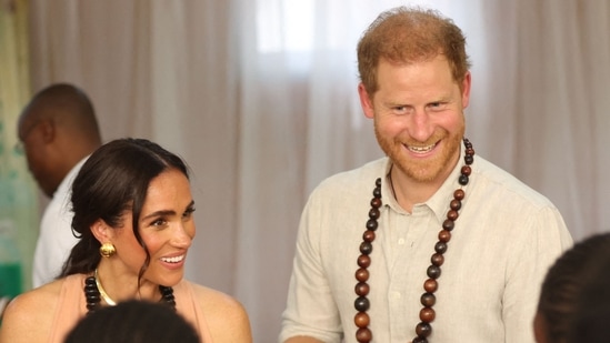 Britain's Meghan (L), Duchess of Sussex, and Britain's Prince Harry (C), Duke of Sussex, speak with students at the Lightway Academy in Abuja on May 10, 2024 as they visit Nigeria as part of celebrations of Invictus Games anniversary. (Photo by Kola Sulaimon / AFP)