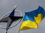 A Ukrainian national flag is pictured in front of the NATO emblem