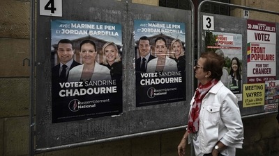 A woman looks at election posters of French far-right Rassemblement National (RN) candidate Sandrine Chadournec (C) in Libourne, southwestern France as part of the French legislative elections. (Photo by Philippe LOPEZ) (AFP) A woman looks at election posters of French far-right Rassemblement National (RN) candidate Sandrine Chadournec (C) in Libourne, southwestern France as part of the French legislative elections. (Photo by Philippe LOPEZ) (AFP)