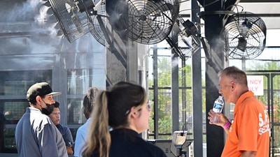 Security staff members cool off near cooling fans at Allegiant Stadium in Las Vegas on July 6, 2024 during a record-breaking heatwave in the US. The administration of US President Joe Biden on July 2, proposed new regulations aimed at protecting laborers working in extremely high temperatures, as heat waves intensified by climate change increasingly blanket the nation. The rule would be aimed at mail carriers, delivery people, construction workers, landscapers, restaurant staff and others exposed to consistently high heat indexes, which measures how the temperature actually feels to humans. (Photo by Frederic J. BROWN / AFP) (AFP) Security staff members cool off near cooling fans at Allegiant Stadium in Las Vegas on July 6, 2024 during a record-breaking heatwave in the US. The administration of US President Joe Biden on July 2, proposed new regulations aimed at protecting laborers working in extremely high temperatures, as heat waves intensified by climate change increasingly blanket the nation. The rule would be aimed at mail carriers, delivery people, construction workers, landscapers, restaurant staff and others exposed to consistently high heat indexes, which measures how the temperature actually feels to humans. (Photo by Frederic J. BROWN / AFP) (AFP)
