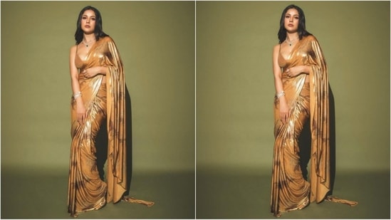 Her stunning saree boasts a captivating blend of gunmetal and brown hues, adorned with enchanting floral prints. She draped the nine yards in a traditional style, allowing the pallu to cascade gracefully from her shoulder, sweeping the floor with elegance.(Instagram/@Shehnaaz Gill)