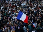 People hold French flags as they gather at the Place de la Republique after partial results in the second round of the early French parliamentary elections, in Paris, France