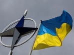 A Ukrainian national flag is pictured in front of the NATO emblem