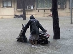 A man wades through a waterlogged road with his scooty at Taloja MIDC in Navi Mumbai.  (Bachchan Kumar/ HT PHOTO)