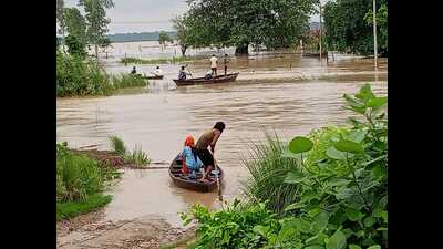 People from Tikunia area in Nighasan tehsil on the Indo-Nepal border use small fishing boats to escape to safety as floodwaters inundate their village on Monday. (HT) People from Tikunia area in Nighasan tehsil on the Indo-Nepal border use small fishing boats to escape to safety as floodwaters inundate their village on Monday. (HT)