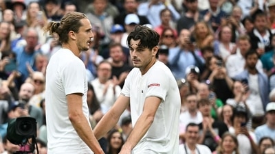 Taylor Fritz (R) speaks with Germany's Alexander Zverev at the end of their men's singles tennis match (AFP)