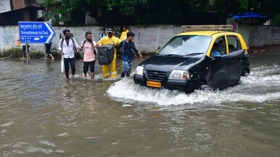 Rescue personnel help people wade through the waterlogged road at Sion, in Mumbai on Monday. ((HT Photo by Bhushan Koyande)) Rescue personnel help people wade through the waterlogged road at Sion, in Mumbai on Monday. ((HT Photo by Bhushan Koyande))