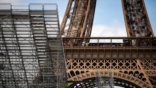 Workers build the Eiffel Tower Stadium that will host the Beach Volleyball and men's Blind Football competitions during the upcoming Paris 2024 Olympics on April 3, 2024 in the Champ-de-Mars garden in Paris. 