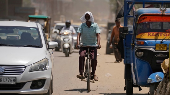 FILE- A man covers his face with a cloth to shield from the heat in Jammu, India, Monday, May 20, 2024. A monthslong heatwave across swathes of India has killed more than 100 people and led to over 40,000 suspected cases of heat stroke in the last three and a half months, a Health Ministry official said Thursday, June 20. (AP Photo/Channi Anand)