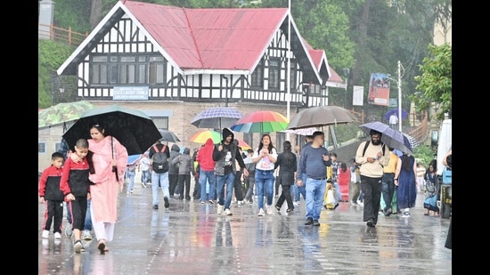 People enjoying rain at, The Ridge, in Shimla on Sunday. (Deepkak Sansta/HT)