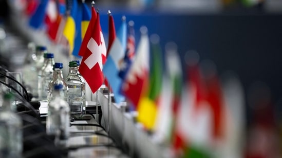 This photograph shows the Swiss flag set among the flags of the other countries during a plenary session at the Summit on peace in Ukraine, at the luxury Burgenstock resort, near Lucerne. (Photo by URS FLUEELER / POOL / AFP)