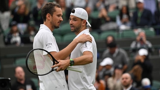 Bulgaria's Grigor Dimitrov (R) is consoled by Russia's Daniil Medvedev after retiring from their men's singles fourth round tennis match on the seventh day of the 2024 Wimbledon Championships at The All England Lawn Tennis and Croquet Club in Wimbledon, southwest London, on July 7, 2024. (Photo by ANDREJ ISAKOVIC / AFP) / RESTRICTED TO EDITORIAL USE(AFP)