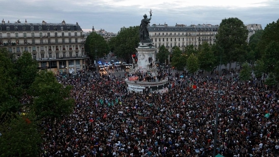 People gather during an election night event following the first results of the second round of France's legislative election at Republique Square in Paris.(AFP)