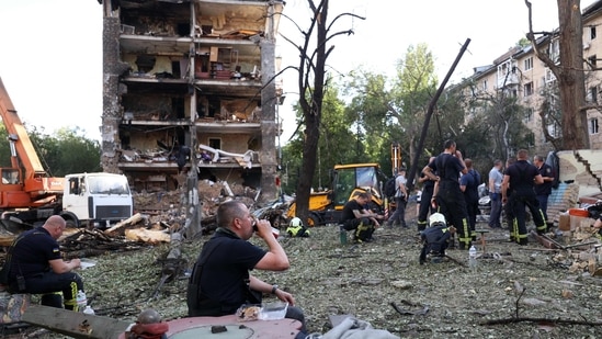 Rescuers rest as they work near apartment buildings and a kindergarten destroyed by a missle strike in Kyiv, on July 8, 2024, amid the Russian invasion of Ukraine. Russia struck cities across Ukraine on July 8, 2024, with a missile barrage that killed 33 people and ripped open a children's hospital in Kyiv. (AFP)