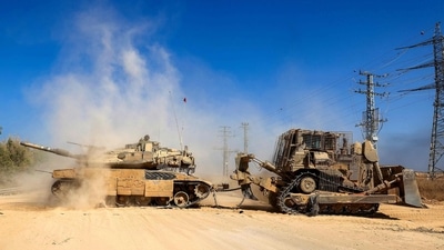 A bulldozer tows an Israeli tank in an area near Israel's southern border with the Gaza Strip on July 9, 2024, amid the ongoing conflict between Israel and the Palestinian militant group Hamas. (AFP) A bulldozer tows an Israeli tank in an area near Israel's southern border with the Gaza Strip on July 9, 2024, amid the ongoing conflict between Israel and the Palestinian militant group Hamas. (AFP)