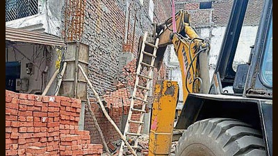 MC teams, led by assistant town planner (ATP) Harvinder Singh Honey, sealed two illegal labour quarter buildings and four shops in Sherpur area. (HT Photo)