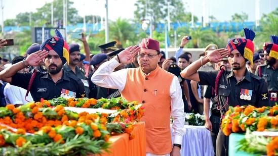 Dehradun, Jul 09 (ANI): Uttarakhand CM Pushkar Singh Dhami pays last respect to the mortal remains of the five soldiers of state who lost their lives in the Kathua terrorist attack, at Jolly Grant Airport in Dehradun on Tuesday. (ANI Photo)