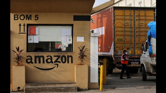 FILE PHOTO: A man inspects trucks before they enter an Amazon storage facility on the outskirts of Mumbai, India, October 1, 2021. Picture taken October 1, 2021. REUTERS/Francis Mascarenhas//File Photo (REUTERS)