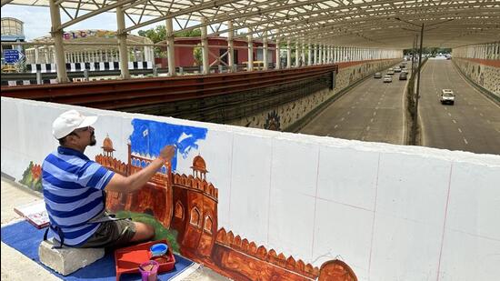 Manoj has been commissioned by an art academy to paint the entire stretch of the outer wall of an underpass near Bharat Mandapam in Pragati Maidan with Delhi’s Unesco world heritage monuments. (HT Photo)