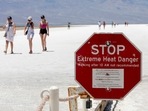 A stop sign warns tourists of extreme heat at Badwater Basin in Death Valley National Park, California. Tourists defy heatwave warnings by US to capture Death Valley's unique landscape(Photo by Daniel Jacobi II/Las Vegas Review-Journal via AP)