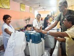 Polling officials collect EVM and other election materials at a distribution centre for the Maniktala assembly bypoll, in Kolkata, Tuesday. (PTI)