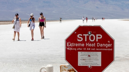 A stop sign warns tourists of extreme heat at Badwater Basin in Death Valley National Park, California. Tourists defy heatwave warnings by US to capture Death Valley's unique landscape(Photo by Daniel Jacobi II/Las Vegas Review-Journal via AP)