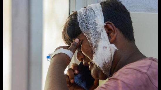 Dilshad, who was a co-passenger in the bus, grieves while talking on the mobile phone as he arrives at the district hospital to identify bodies of 6 members of his family after a collision between a tanker and a bus, in Unnao district, Wednesday. (PTI Photo)