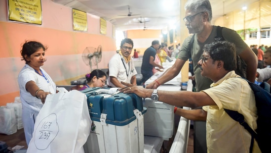 Polling officials collect EVM and other election materials at a distribution centre for the Maniktala assembly bypoll, in Kolkata, Tuesday. (PTI)