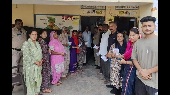 Residents of Nalagarh showing their voter identity cards before voting in the byelection in Solan district on Wednesday. (HT Photo)