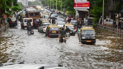Commuters wade through a waterlogged road at Dadar after a monster thunderstorm caused heavy rains in Mumbai and adjoining areas on Monday (PTI) Commuters wade through a waterlogged road at Dadar after a monster thunderstorm caused heavy rains in Mumbai and adjoining areas on Monday (PTI)