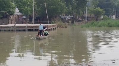 People moving to a safer place in boat after their village was flooded by Sharda river in Kheri’s Dhaurahra tehsil on July 11. (HT photo)