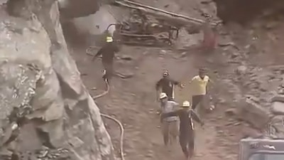 Workers clearing debris on the Badrinath Highway narrowly escaped when boulders fell near them. (X) Workers clearing debris on the Badrinath Highway narrowly escaped when boulders fell near them. (X)