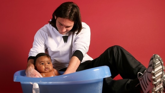 20-year-old Lionel Messi bathing Lamine Yamal, who was merely six months old at the time, during a photo session in the dressing room of the Camp Nou stadium in Barcelona, Spain, in September 2007.(AP)