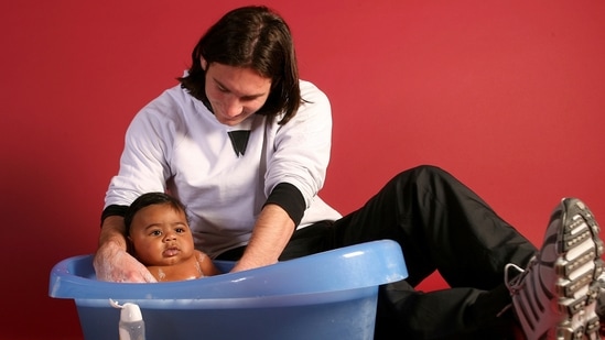 This photo taken in September 2007 shows a 20-year-old Lionel Messi helping to bathe Lamine Yamal, who was merely six months old at the time during a photo session.(AP)