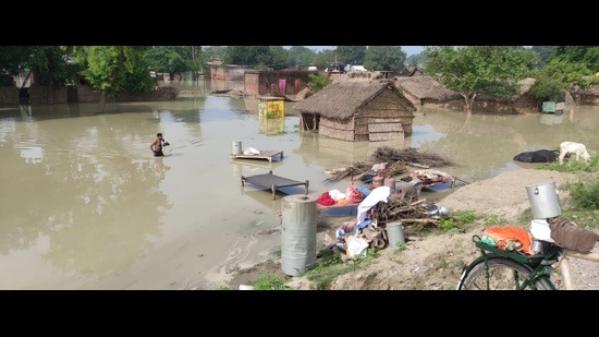 Villagers ferrying on boats after their village adjacent to highway went flooded by Sharda river in Dhaurahra tehsil on Thursday. (Deo Kant Pandey)