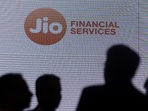 People stand next to a logo of Jio Financial Services.(Reuters)