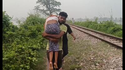 Manoj carrying his sister’s body on his shoulders on Thursday during floods in Bhira region. (Sourced)