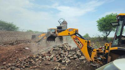 Officials from the forest department seen demolishing a wall of a farmhouse built in the Aravalli area on the hill of Raisina village, in Gurugram on July 12. (HT Photo) Officials from the forest department seen demolishing a wall of a farmhouse built in the Aravalli area on the hill of Raisina village, in Gurugram on July 12. (HT Photo)