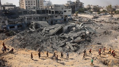 People walk on rubble at the damaged UN Relief and Works Agency for Palestine Refugees (UNRWA) building complex in western Gaza City's Al-Sinaa neighbouhood on July 12, 2024. (AFP) People walk on rubble at the damaged UN Relief and Works Agency for Palestine Refugees (UNRWA) building complex in western Gaza City's Al-Sinaa neighbouhood on July 12, 2024. (AFP)