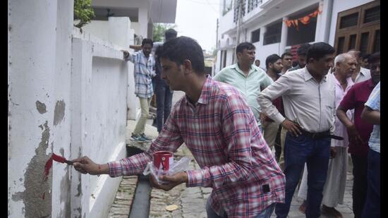 A team of government agencies putting a red mark on a house in Lucknow’s Rahim Nagar. (HT Photo)