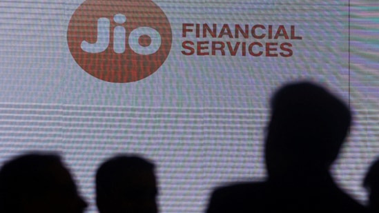 People stand next to a logo of Jio Financial Services.(Reuters)