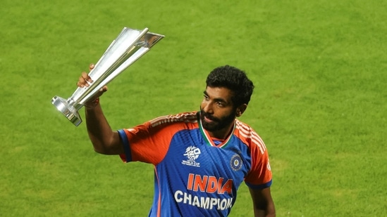 India's Jasprit Bumrah waves the World Cup trophy before a victory lap at the Wankhede stadium in Mumbai(REUTERS)