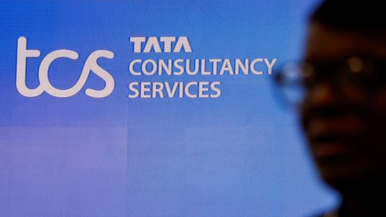 TCS share price: A man walks past a logo of Tata Consultancy Services (TCS) before a press conference.(Reuters)