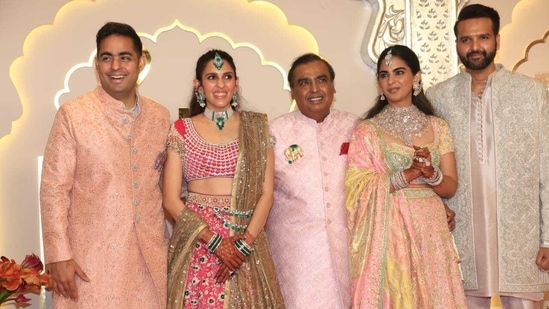 Akash Ambani, Isha Ambani and Mukesh Ambani wore blush pink embroidered traditional ensembles. Meanwhile, Shloka wore a bright pink lehenga. (HT Photo/Varinder Chawla)